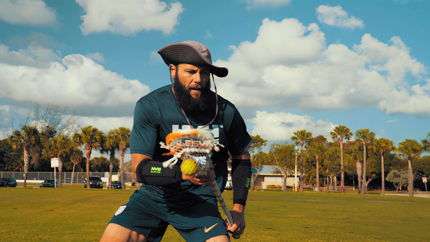 a lacrosse player cradling a ball in his stick while wearing a pair of HVY Sleeves