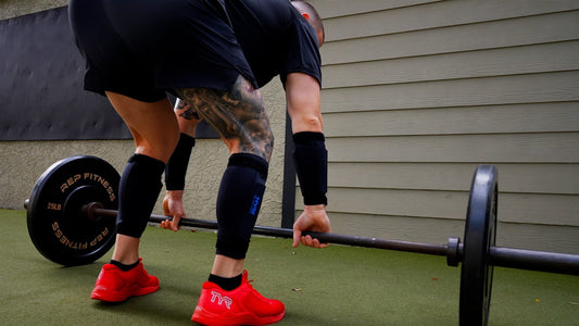 a man preparing to deadlift while wearing weighted leg and ankle weights